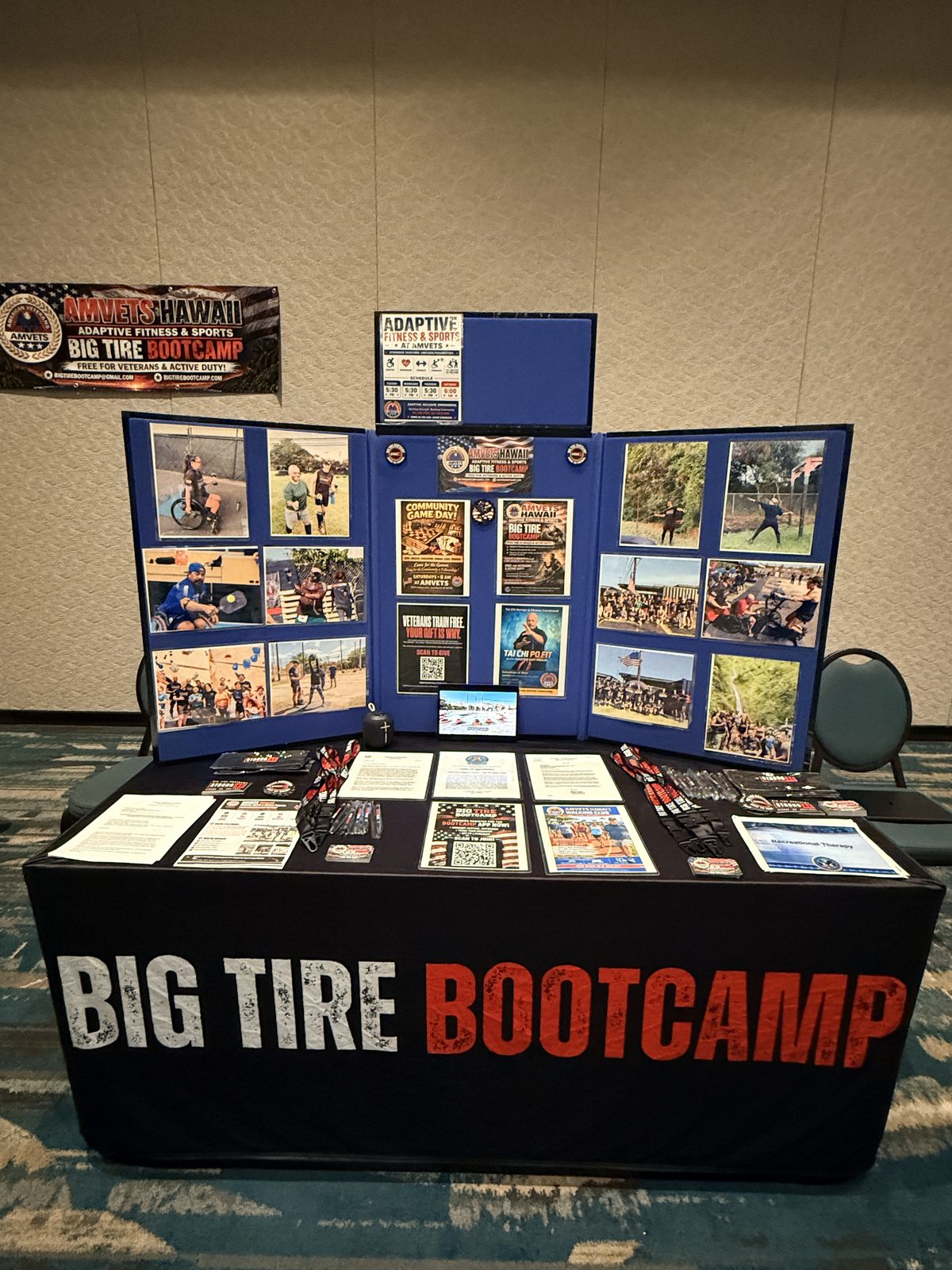 The Big Tire Bootcamp exhibit table with a display board of adaptive fitness program photos and flyers.
