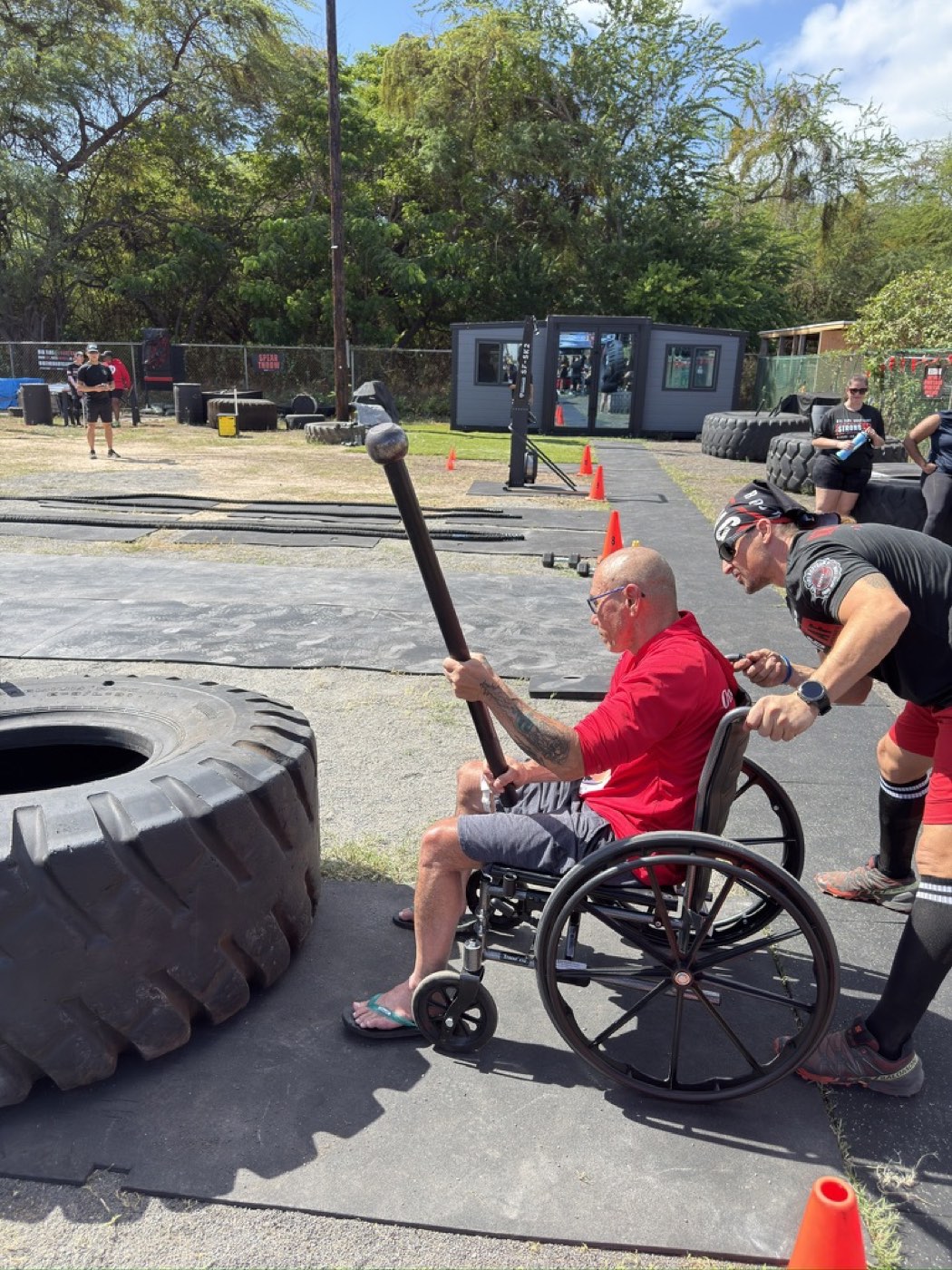 Veteran striking the big tire with a mace at the Koa Challenge adaptive fitness event